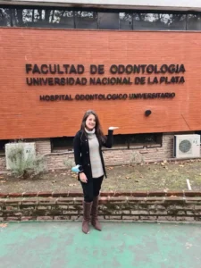 Assessora da Adelante Assessoria em frente à Faculdade de Odontologia da UNLP realizando trâmites de matrícula para alunos brasileiros.